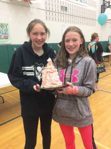 Jenna and Paige enjoy a cake won from the Cake Walk game, which they will have for their upcoming birthdays.
