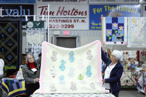 This year at the show there was a bed turning event where historical quilts were individually displayed with an accompanying story. Donna Ireland and Betty Stringer, below, are holding up one of 21 quilts submitted for the event. 